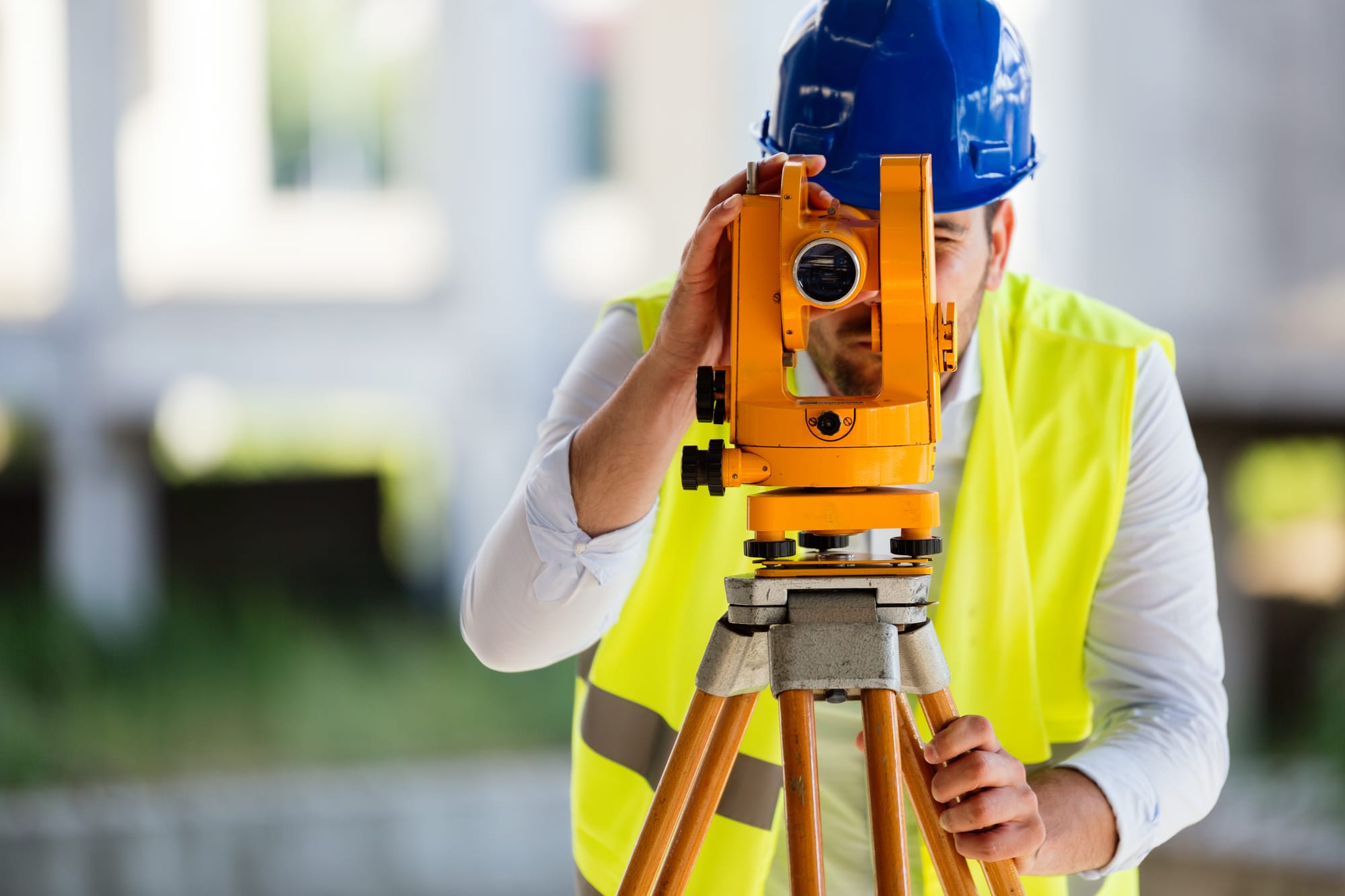 Topograf care realizează măsurători cu stația totală